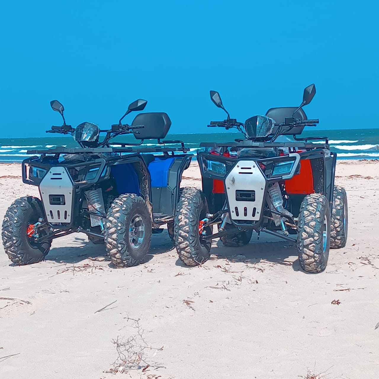 Quad bikes on the beach with ocean and blue sky